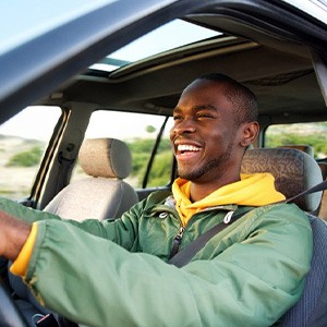 Man smiles while driving