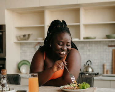 Woman smiling while eating lunch at home