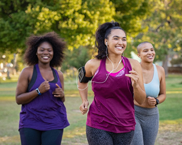 Group of friends smiling on run together in park