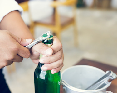 Person using bottle cap remover